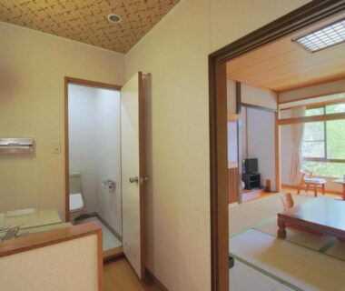 Tatami room with low table, cushions, sink and sliding screens at Kounso, Yamanashi