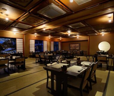 Spacious tatami dining area with low wooden tables, shoji screens and warm lantern lighting at Kouyurou Ikawa, Shizuoka