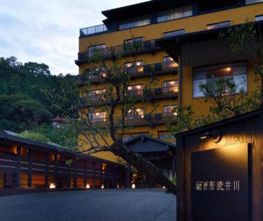 Illuminated multi-story ryokan exterior with lit balconies at Kouyurou Ikawa in Shizuoka