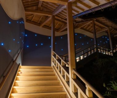 Covered wooden stairway with warm step lighting and blue decorative wall lights at Koyasan Sanadabo Rengejoin, Wakayama