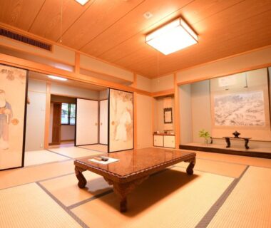 Traditional tatami room with low wooden table, painted fusuma panels and tokonoma alcove at Koyasan Shukubo Fugenin, Wakayama