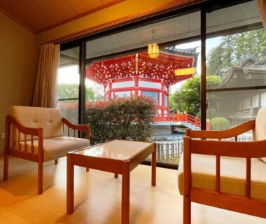 Tatami seating area with chairs and table overlooking red pagoda at Koyasan Shukubo Fugenin Wakayama