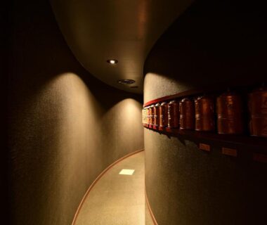 Curved dimly lit corridor with wooden wall fixtures at Koyasan Shukubo Fugenin, Wakayama, Kansai
