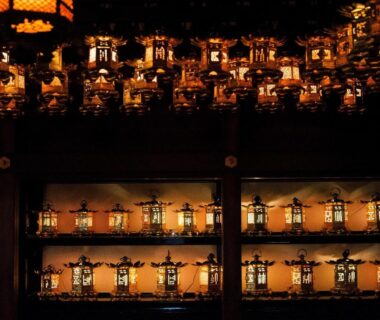 Rows of lit hanging lanterns lining a dim interior at Koyasan Shukubo Jokiin, Wakayama