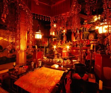 Red and gold temple altar interior with lanterns and hanging ornaments at Koyasan Shukubo Saizenin, Wakayama