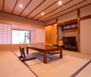 Traditional tatami room with low wooden table, floor chairs, shoji screens and garden-facing window at Koyasan Shukubo Saizenin Wakayama