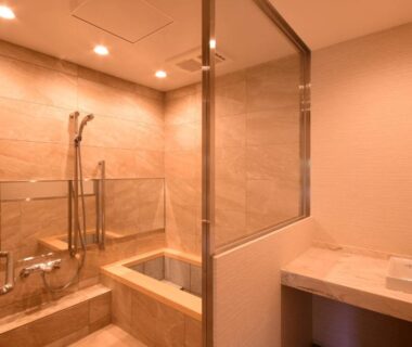 Interior bathroom with tiled tub, glass shower partition and vanity at Koyasan Shukubo Saizenin, Wakayama