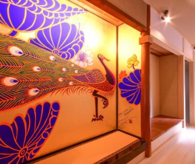 Interior corridor with colorful peacock mural, wooden flooring and recessed alcove at Koyasan Shukubo Saizenin, Wakayama