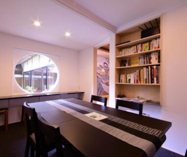 Dining area with round window and bookshelf at Koyasan Shukubo Saizenin, Wakayama