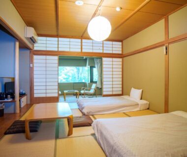 Tatami room with low table, shoji screens and twin beds at Kozuka Hisanoha Kanagawa