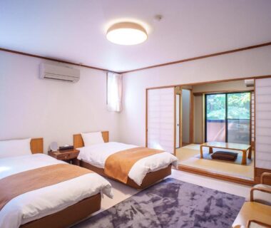 Twin beds with adjacent tatami area, shoji screens and greenery outside at Kozuka Hisanoha, Kanagawa