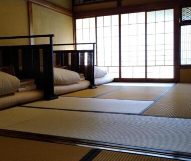 Tatami room with futons and low table at K's House Ito Onsen, Shizuoka, Chūbu, Japan