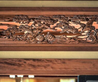 Ornate carved wooden transom (ranma) above doorway at K's House Ito Onsen, Shizuoka, Chūbu, Japan