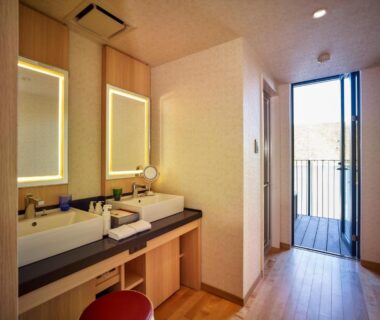 Double sink bathroom with lit mirrors and wooden floor at Kumano-bettei Nakanoshima, Wakayama