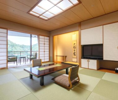 Traditional tatami room with low table, zabuton chairs, shoji screens and balcony view at Kumano-bettei Nakanoshima in Wakayama