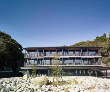Multi-story ryokan building beside rocky shoreline at Kumano-bettei Nakanoshima in Wakayama