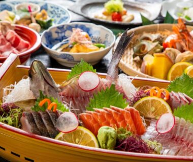 Assorted sashimi in wooden boat at Kunisakisou ryokan table in Oita