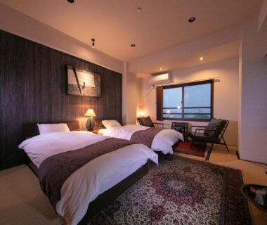 Tatami room with twin beds, window seating and rug at Kunisakisou Oita