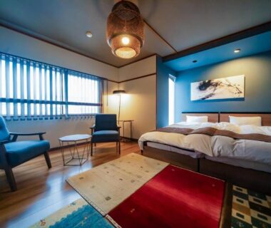 Twin beds, lounge chairs and shoji-style window in Kunisakisou guest room, Ōita, Kyūshū