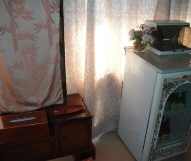 Curtained corner with wooden storage chests and decorative cabinet at Kurhaus Ishibashi Ryokan in Shizuoka