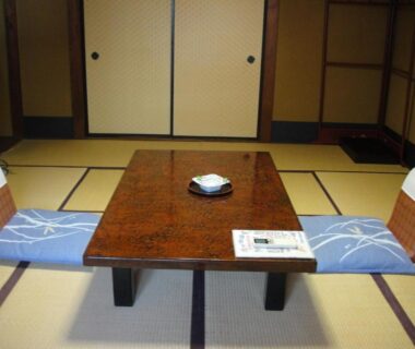Low lacquer table with zabuton cushions and fusuma doors in tatami room at Kurhaus Ishibashi Ryokan, Shizuoka, Chūbu, Japan
