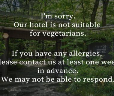 Sign advising guests the hotel may not suit vegetarians and requesting allergy notice, placed along a garden path