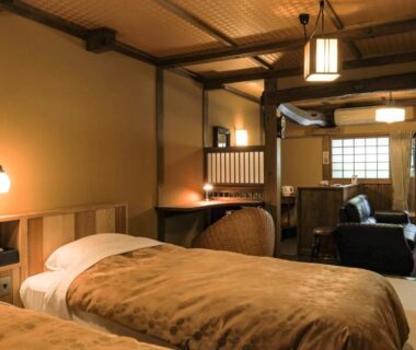 Tatami room with twin beds, shoji screens and seating at Kurokawa Onsen Oyado Noshiyu, Kumamoto, Kyūshū
