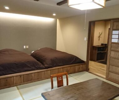 Tatami room with futons, low table and shoji door at Kurokawa Onsen Ryokan Ichinoi, Kumamoto