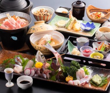 Assorted sashimi, tempura, simmered dishes and condiments on lacquer trays at Kurosakisou Kyoto ryokan dining