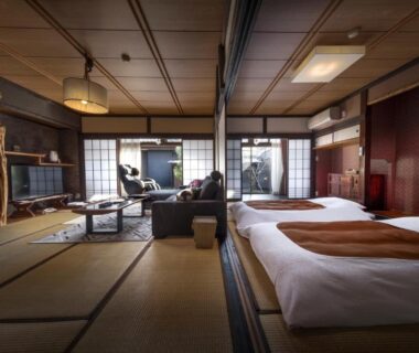 Spacious tatami room with Western beds, shoji screens and seating at Kurotake in Nagano