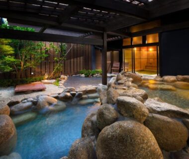 Stone-lined outdoor onsen under wooden canopy at Kurotake, Chūbu, Nagano, Japan