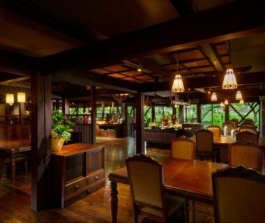 Warm wooden dining lounge with tables and garden views at Kurotake ryokan in Nagano, Chūbu, Japan