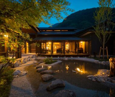 Night-lit courtyard with pond and stepping stones at Kurotake in Nagano