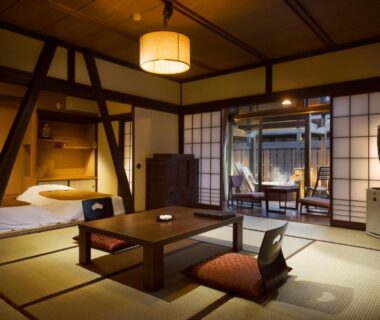 Tatami room with low table, futon alcove, shoji screens and courtyard view at Kurotake ryokan Nagano