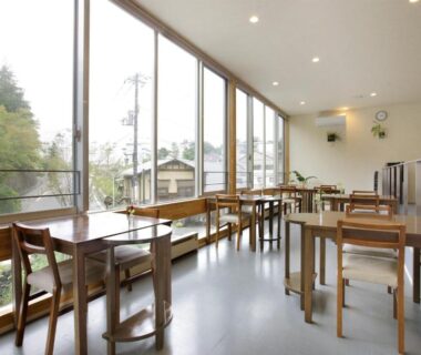 Bright dining area with floor-to-ceiling windows and wooden tables at Kusatsu Hotel Bekkan Wata no Yu, Gunma, Kantō