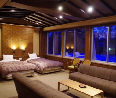 Spacious room with twin beds, sofa seating and large windows at Kusatsu Skyland Hotel, Gunma, Kantō