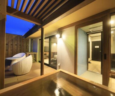 Wooden outdoor onsen bath with terrace seating and sliding doors at KusatsuOnsen AeruyadoTakamatsu, Gunma