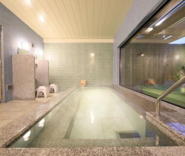 Tiled indoor onsen with washing stools at KusatsuOnsen AeruyadoTakamatsu, Gunma