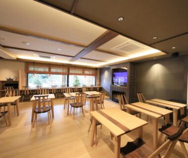 Spacious wooden dining area with tables, chairs and large windows overlooking greenery at KusatsuOnsen AeruyadoTakamatsu, Gunma