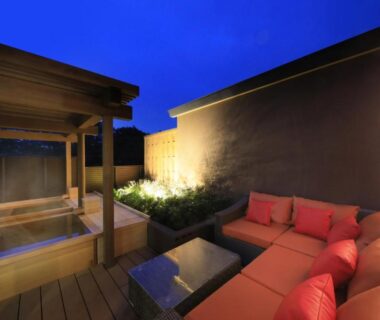 Wooden outdoor bath beside deck sofa at KusatsuOnsen AeruyadoTakamatsu in Gunma Kantō