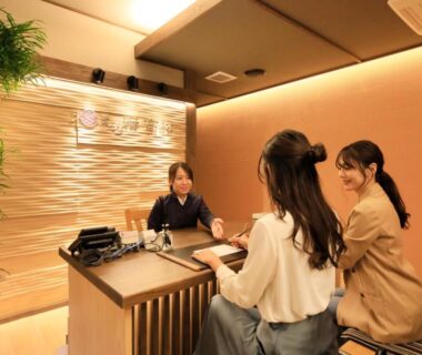 Guests at reception desk at KusatsuOnsen AeruyadoTakamatsu, Gunma, with warm interior lighting