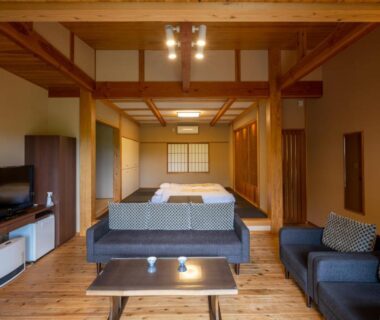 Japanese-style room with tatami area and sofas at Kusayane no yado Ryunohige, Ōita