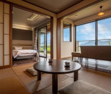 Tatami seating area with low table and western bed at Kusayane no yado Ryunohige in Ōita
