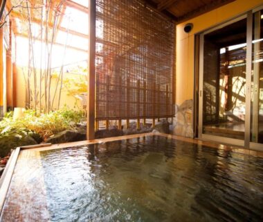 Wooden onsen bath with bamboo screen and garden at Kutsurogi-no-Yado Nanakawa, Ōita, Kyūshū