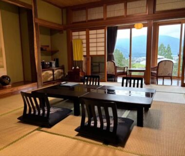 Tatami room with low table, zaisu chairs and shoji doors at Kutsurogian in Niigata