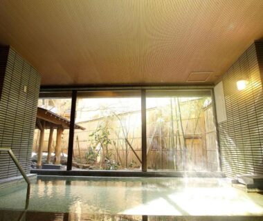 Indoor bathing area with glass wall overlooking bamboo courtyard at Kutsurogijyuku Shintaki, Fukushima