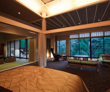 Spacious ryokan room with western bed, tatami seating area and garden-facing windows at Kyo Yunohana Resort Suisen Kyoto