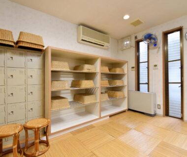 Wooden shelves with wicker baskets and stools in changing room at Kyo no Minshuku Ohara no Sato Kyoto