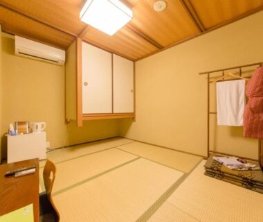 Traditional tatami room with low table, chair, shoji doors and hung yukata at Kyo no Yado Sangen Ninenzaka Kyoto