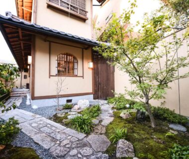 Stone stepping path through moss garden to traditional wooden entrance at Kyo no Yado Sangen Ninenzaka Kyoto